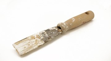Apply exterior-grade wood putty with a putty knife.
