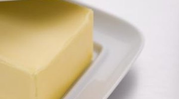 The grease in butter helps loosen ink from vinyl.